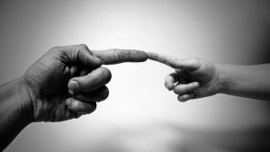 Image symbolique de deux mains qui se touche par l'index en hommage à l'oeuvre de Michel Angelo pour illustrer la communication de crise